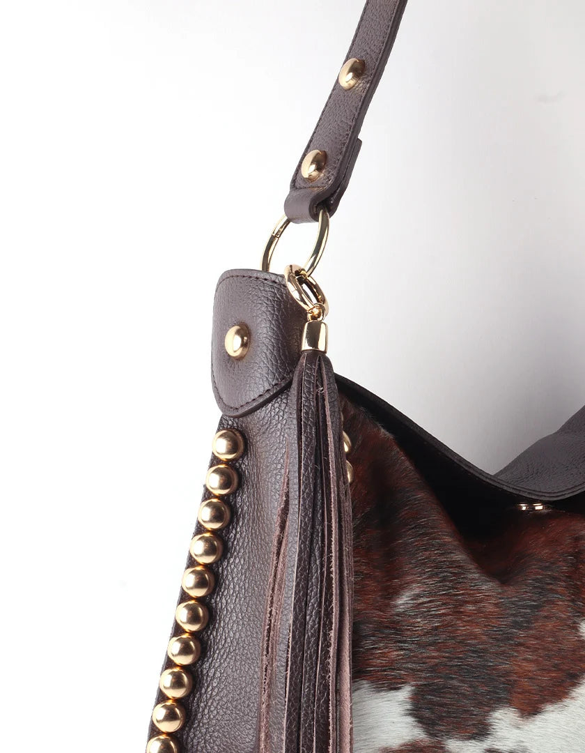 Lederen western hobo-tas met studs, franjes en luxe koeienhuidlook.